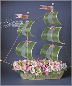 a green boat with pink flowers in it