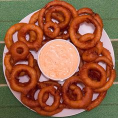 a white plate topped with onion rings and dip