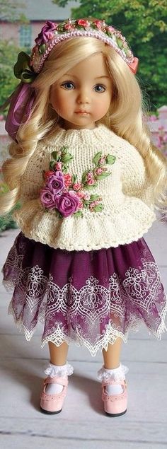 a doll with blonde hair wearing a purple dress and flowered headband is standing in front of a painting