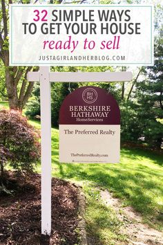 a real estate sign in front of some trees