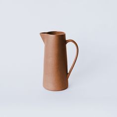 a brown pitcher sitting on top of a white table