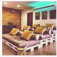 a living room with couches made out of pallets and pillows on the floor