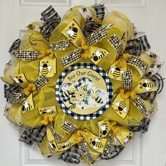 a yellow and black mesh wreath with bees on it that says, bee our child