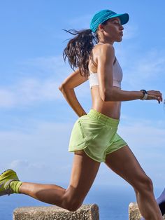 a woman running on the beach in shorts