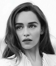 black and white photograph of a woman with long hair wearing a shirt looking at the camera