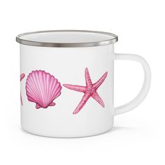 a white enamel mug with pink starfish and seashells painted on the side