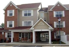 the front entrance to a two story brick apartment building with white trim and large windows