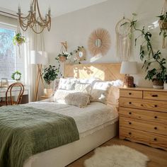 a bedroom with a bed, dresser and plants on the wall in it's corner