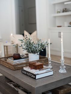 a coffee table with books and candles on it