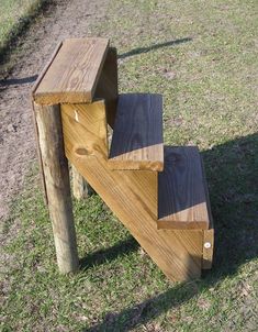 a wooden bench sitting on top of a grass covered field