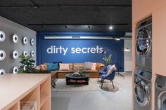 a laundry room with washer, dryer and couches in front of a sign that says dirty secrets