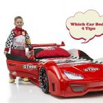 a red race car bed with a boy standing next to it and an empty thought bubble