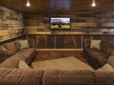 a living room filled with brown couches and a flat screen tv mounted to the wall