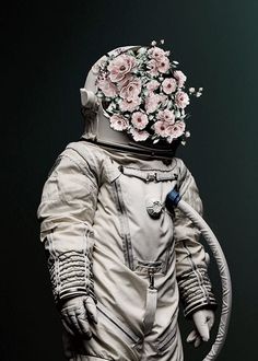 a person in an astronaut suit with flowers on their head