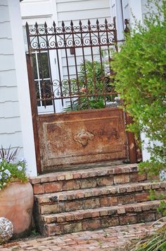 an old trunk is sitting on the steps in front of a house with a gate