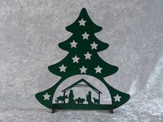 a wooden christmas tree with people in the nativity scene on it's base