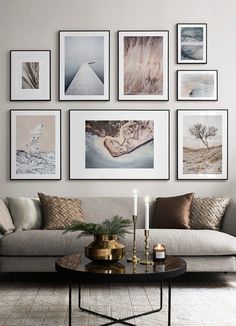 a living room filled with lots of pictures on the wall above a couch and coffee table