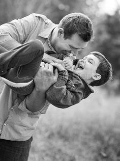 a man is holding his son in the air while he holds him close to his face