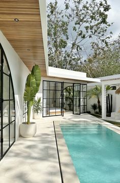 an outdoor swimming pool in the middle of a house with glass walls and doors on both sides