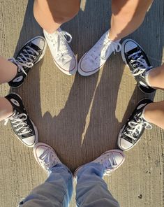 four people standing in a circle with their legs crossed and one person's feet on the ground