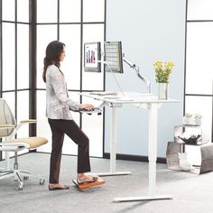 a woman standing in front of a computer desk