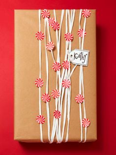 a brown box with red and white lollipops tied to it's sides