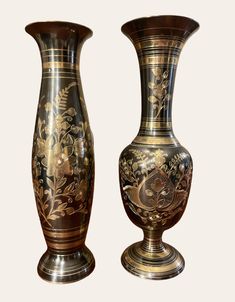 two vases with designs on them sitting next to each other