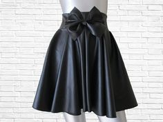 This is a modern and funky twist on your traditional skater skirt. The high waist, center front bow and faux leather gives it that high fashion edge we all love and adore! The bow skater skirt can easily be dressed up or dressed down. Available in sizes XS - 4XL PLEASE view size chart provided before ordering From waist (not top of waistband) to hem this skirt measures 17 inches long ( can be lengthened by request for an additional fee) Ther are no returns accepted for my custom-made items, even exchange or merchandise credit only! In order to receive an even exchange or merchandise credit the item must be returned unworn with all tags attached. The item must be free of any soilage, stains, perfume smells or any other odors. Trendy Party Skort With Flared Skirt, Fitted Flared Skort For Party, Trendy Party Flared Skort, Fitted Full Mini Skirt For Night Out, Chic Party Skirt With Bow, Trendy Fitted Full Mini Skirt, High Waist Pleated Party Skirt, Mini Skirt With Bow Detail, Elegant Flared Skort For Party