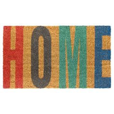 a door mat with the word home written in multicolored letters on top of it