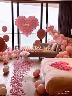 a living room filled with lots of balloons and confetti on the floor next to a couch