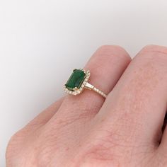 This ring features a beautiful emerald set in a halo ring setting with sparkling natural diamonds all set in 14k solid yellow gold. This design features two tapered baguette diamond accents in the shank. A gorgeous modern look that's perfectly balanced between minimalist and glamour. Emerald Vintage Ring, Emerald Stone Engagement Ring, Emerald Engagement Ring Green, Med Vet, Halo Ring Setting, Emerald Set, Designer Silver Jewellery, Aesthetic Jewelry, Gold Rings Fashion