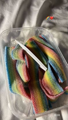 a plastic container filled with rainbow colored cotton swabs