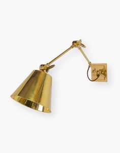 an antique brass wall light with a single arm and a gold shade on the side