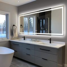 a bath room with a tub and a large mirror