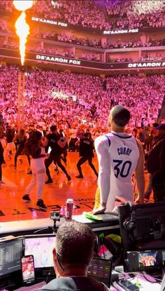 a group of people standing on top of a basketball court in front of a crowd