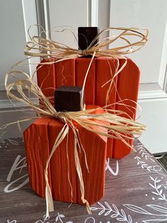 an orange pumpkin made out of wooden sticks and tied with twine, sitting on a table