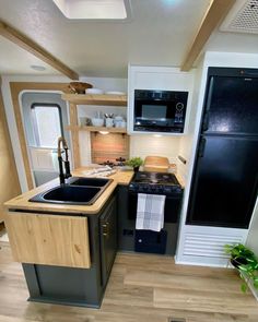 a kitchen area with sink, stove and microwave