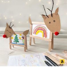 two cardboard reindeers are standing next to each other in front of some art supplies