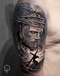 a man with a cross on his shoulder is wearing a crown of jesus tattoo design