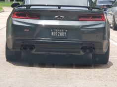 the back end of a gray car parked in a parking lot