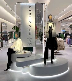 two mannequins are sitting in the middle of a store