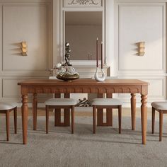 a dining room table with four chairs and a vase on top of it in front of a mirror