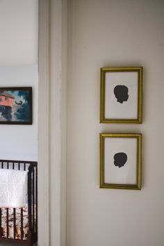 two framed pictures hang on the wall next to a crib