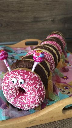 a wooden tray topped with donuts covered in frosting and sprinkles