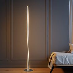 a floor lamp that is next to a bed