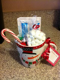 a cup filled with marshmallows, candy canes and toothpaste