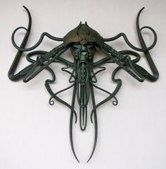 an intricately designed metal wall clock on a white wall