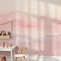 a pink and white room with two chairs in front of the wall that has a painting on it