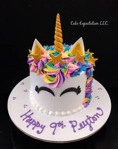 a birthday cake decorated with an unicorn's face