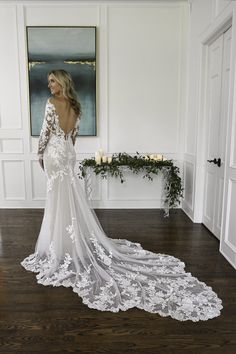 a woman in a wedding dress standing on a wooden floor